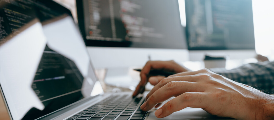 Close up of hands contemporary website developer man typing and writing code for program website and working with partner in office.