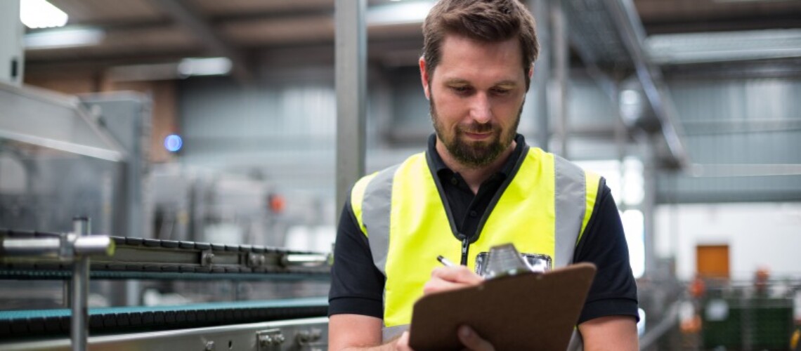 factory-worker-writing-on-clipboard-in-factory-2021-08-28-16-44-40-utc-1