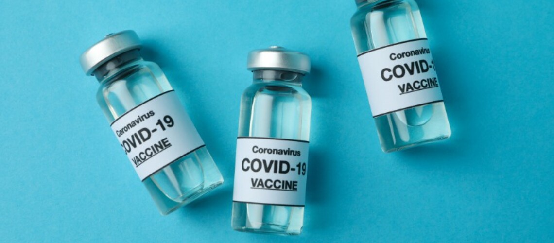 vials-of-covid-19-vaccine-on-blue-background-9UYF89P-1